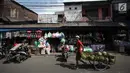 Pedagang gas melintasi kios mainan di Pasar Gembrong, Jakarta, Selasa (9/1). Maret mendatang, Pemprov DKI berencana menggusur kawasan Pasar Gembrong untuk pembangunan tol Becakayu, yang berakhir di Kampung Melayu, Jatinegara. (Liputan6.com/Arya Manggala)