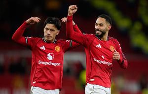 Pemain Manchester United, Matheus Cunha (kanan), dan Lisandro Martinez, merayakan kemenangan timnya dalam laga Liga Inggris melawan Newcastle di Old Trafford, Sabtu, 27 Desember 2025. (AP Photo/Dave Thompson)