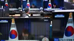 Seorang penjaga toko menyaksikan layar televisi yang menampilkan siaran langsung Presiden Korea Selatan Yoon Suk Yeol yang membungkuk setelah mengakhiri pidatonya, di sebuah pasar elektronik di Seoul pada Sabtu 7 Desember 2024. (Jung Yeon-je/AFP)