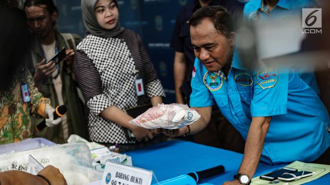 Kepala BNN, Komjen Heru Winarko memeriksa barang bukti narkoba sebelum pemusnahan di Gedung BNN, Jakarta, Jumat (1/3). BNN memusnahkan sebanyak 99,7 Kg sabu, 9.990 butir ekstasi dan 118,34 kg daun khat. (Liputan6.com/Faizal Fanani)