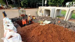 Pekerja menggali lubang untuk pengerjaan penataan jalur pedestrian di Jalan Sisingamangaraja, Jakarta Selatan, Jumat (4/5). Perbaikan tersebut untuk memperlancar aliran air saat musim penghujan tiba. (Liputan6.com/JohanTallo)