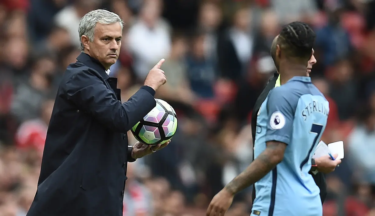 Pelatih Manchester United,  Jose Mourinho menahan bola saat pemain Manchester City, Raheem Sterling hendak mengambilnya  pada laga Premier League di Old Trafford, Manchester,  (10/9/2016). (AFP/Oli Scarff)
