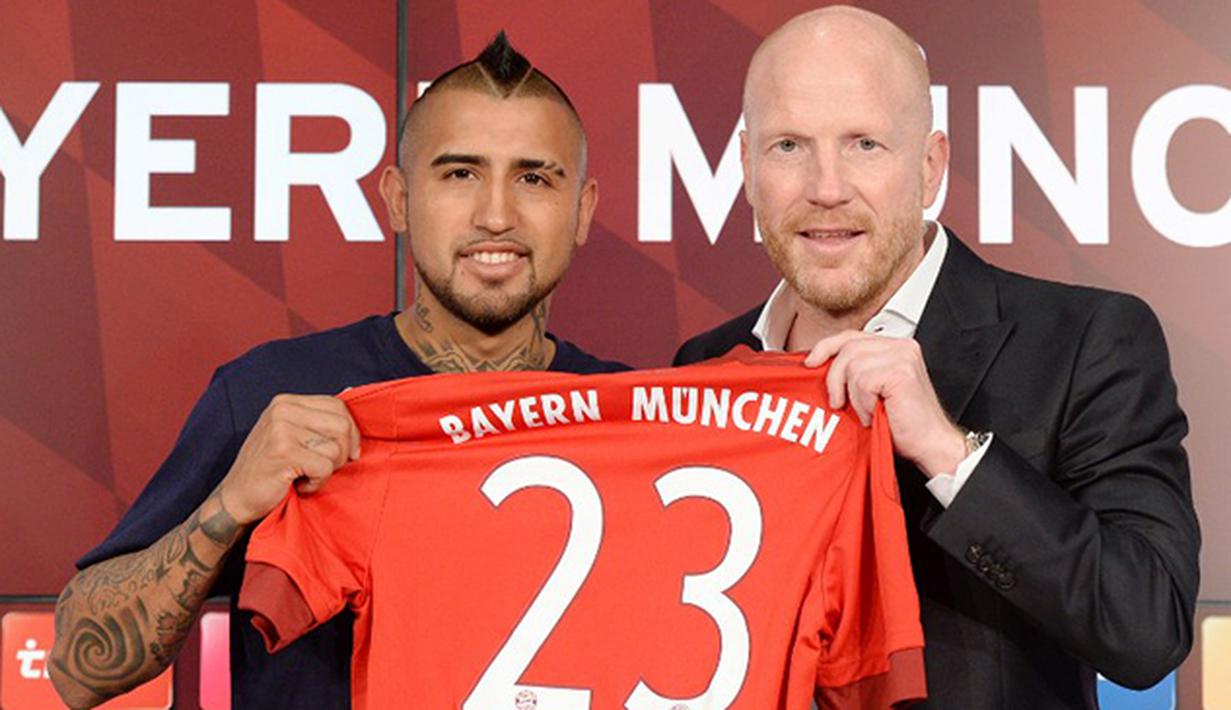 Direktur Olahraga Bayern Munchen Matthias Sammer (kanan) memperkenalkan pemain baru dari Munchen Arturo Vidal (kiri) saat jumpa pers di Munich, Jerman, Selasa (28/7/2015). (AFP Photo/Christof Stache)