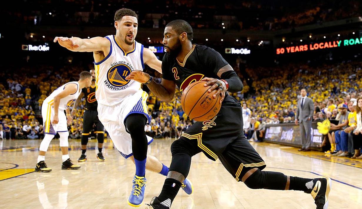 Pebasket Cleveland Cavaliers, Kyrie Irving, berusaha melewati pebasket Golden State Warriors, Klay Thompson pada gim ketujuh final NBA. Irving menjadi penentu keunggulan Cavs melalui tembakan tiga angka. (AFP/Ezra Shaw)