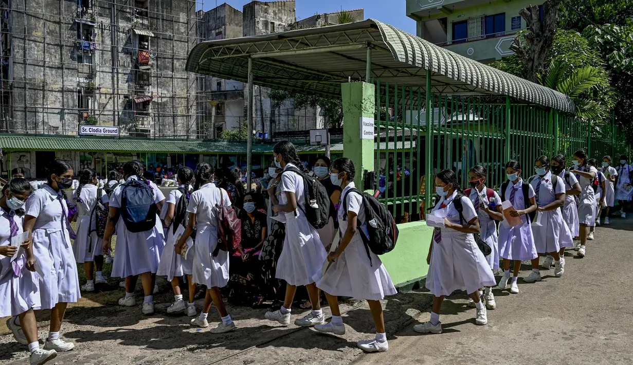 Para siswi kelompok usia 12-15 tahun mengantre untuk mendapatkan suntikan vaksin Pfizer-BioNTech terhadap virus corona Covid-19 di sebuah lembaga pendidikan di Kolombo, Sri Lanka (7/1/2022). (AFP/Ishara S. Kodikara)