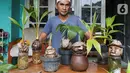 Pengrajin tanaman, Herman Ronda bersama bonsai kelapa yang dikreasi dengan unik di Jalan Salak, Pamulang, Tangerang Selatan, Senin (13/10/2020). Perawatan bonsai batok kelapa sangatlah mudah, hanya disiram dengan air garam dan ditempatkan pada suhu yang lembab. (Liputan6.com/Fery Pradolo)