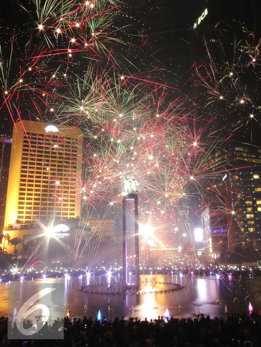 Warga saat menikmati malam tahun baru dengan dengan pertunjukan kembang api di Bundaran HI, Jakarta, Jumat (1/1/2016) malam. Kemeriahan kembang api tersebut merupakan bentuk perayaan pergantian tahun 2015 menuju 2016. (Liputan6.com/Angga Yuniar)