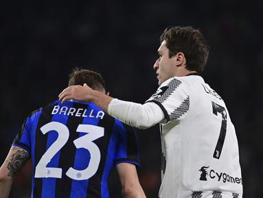 Pemain Juventus Federico Chiesa (kanan) memberi isyarat kepada pemain Inter Milan Nicolo' Barella pada pertandingan sepak bola leg pertama semifinal Coppa Italia di Allianz Stadium, Turin, Italia, Selasa (4/4/2023). (Marco Alpozzi/LaPresse via AP)