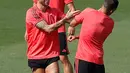 Bek Real Madrid, Sergio Ramos (kiri) bercanda dengan Lucas Vazquez saat berlatih di Madrid, Spanyol, Selasa (18/9). Real Madrid siap menjamu AS Roma pada laga pembuka Grup G Liga Champions. (AP Photo/Paul White)