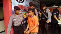 Sholeh, 23 tahun, tersangka pembunuhan saat tiba di Mapolres Bangkalan. (liputan6.com/Musthofa Aldo)