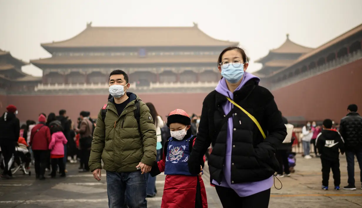 Keluarga tiba di pintu masuk Kota Terlarang pada hari kedua Tahun Baru Imlek di pintu keluar Kota Terlarang di Beijing (13/2/2021). Tahun Baru Imlek menandai Tahun Sapi pada 12 Februari. (AFP Photo/Noel Celis)