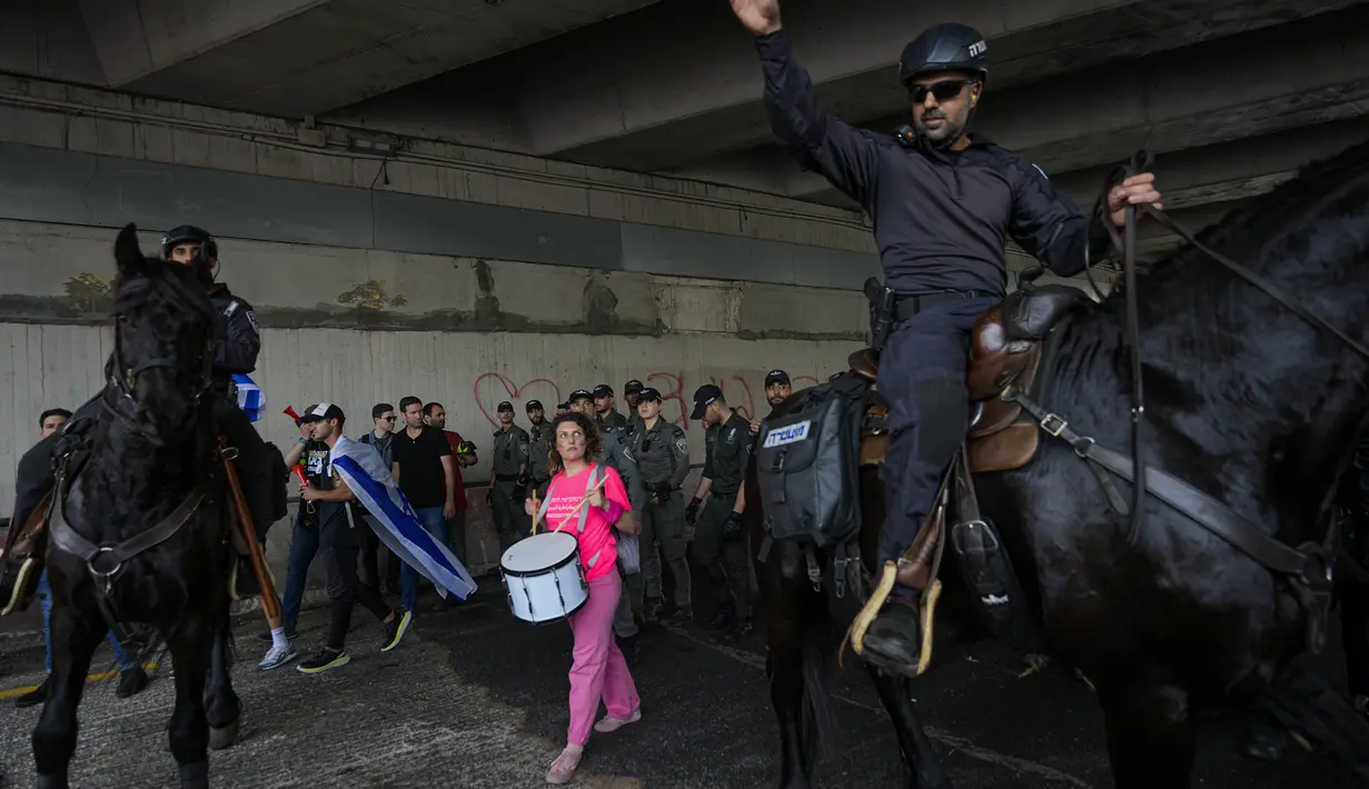 Mereka memblokir jalan raya utama, membakar ban di dekat pelabuhan penting dan mengibarkan bendera besar Israel dan spanduk dengan Deklarasi Kemerdekaan negara itu di atas tembok Kota Tua Yerusalem. (AP Photo/Oded Balilty)