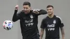 Penyerang Argentina Lionel Messi (kiri) menatap bola di sebelah gelandang Leandro Paredes selama sesi latihan di Ezeiza, Buenos Aires, Rabu (13/10/2021). Argentina dan Peru berhadapan dalam lanjutan Kualifikasi Piala Dunia 2022 zona Amerika Selatan pada Jumat (15/10) pagi WIB. (JUAN MABROMATA/AFP)