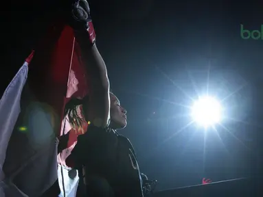 Priscilla Hertati Lumban Gaol mengibarkan bendera Merah-Putih pada ajang One Championship 2018 di Jakarta Convention Center, Sabtu (12/5/2018). Priscilla menang padan ronde pertama. (Bola.com/Nick Hanoatubun)