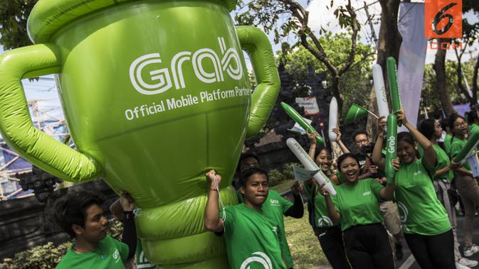 Sejumlah mitra dari Grab membawa balon raksasa saat pawai obor Asian Games XVIII di Denpasar, Bali, Selasa (24/7/2018). Sebanyak 53 kota di Indonesia akan dilalui oleh obor Asian Games. (Bola.com/Vitalis Yogi Trisna)