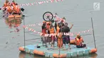 Tim pemenang mengangkat sepeda sebagai hadiah usai menjuarai lomba dayung di Kanal Banjir Timur, Jakarta, Sabtu (17/8/2019). Dalam memeriahkan HUT ke-74 RI, petugas UPK Badan Air DLH Kecamatan Duren Sawit menggelar sejumlah perlombaan, salah satunya lomba dayung. (merdeka.com/ Iqbal S. Nugroho)