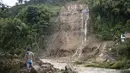 Seorang pria menghadapi lereng bukit yang diguyur hujan yang runtuh menimpa rumah-rumah penduduk di Pereira, Kolombia, Selasa (8/2/2022). Hujan deras memicu tanah longsor menewaskan sedikitnya 14 orang dan melukai 35 lainnya. (AP Photo/Andres Otalvaro)