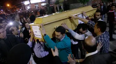 Umat Kristen Mesir menggotong peti jenazah korban serangan bom di Gereja Koptik St. George, Kota Tanta, utara Kairo, Minggu (9/4). Prosesi pemakaman digelar bagi 27 korban serangan teror bom yang terjadi tepat pada perayaan Minggu Palma itu (STRINGER/AFP)