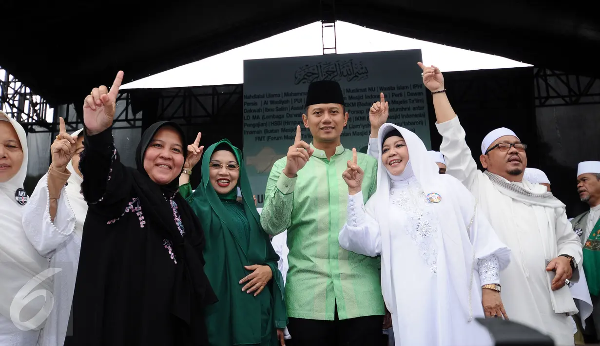 Cagub DKI Jakarta, Agus Harimurti Yudhoyono (AHY tengah) mengangkat tangan usai menyampaikan sambutan saat Doa Bersama Untuk Satukan Umat Jakarta di Lapangan Blok S, Jakarta, Kamis (9/2). (Liputan6.com/Helmi Fithriansyah)