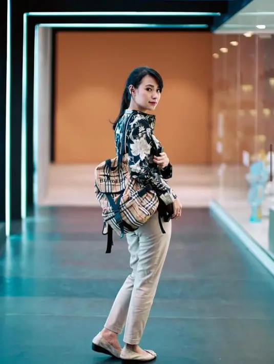 Untuk tampilan kasual, Risa memilih tas backpack yang praktis dan multifungsi. Tas ini dapat memuat beragam kebutuhan dan juga terlihat keren. Tak lupa ia memadukannya dengan celana khakis dan dan kemeja bercorak tropikal yang atraktif. (Sumber: Instagram/santosorisa)