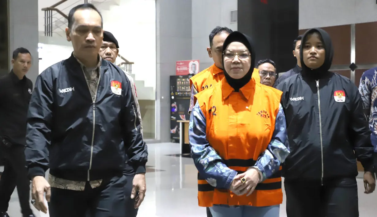 Bupati Sukoharjo Etik Suryani mengenakan rompi tahanan  dibawa menuju mobil tahanan usai menjalani pemeriksaan di Gedung Merah Putih KPK, Jakarta, Sabtu (11/7/2026). (KLY/Arie Basuki)