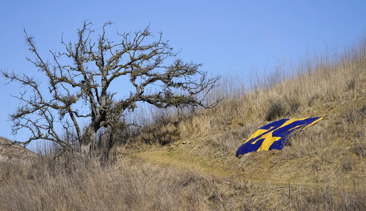 Nomor 24 Kobe Bryant ditempatkan di sepanjang jalan setapak yang mengarah ke lokasi kecelakaan helikopter yang menewaskan Bryant, putrinya Gianna, dan tujuh lainnya satu tahun lalu di Calabasas, California, Amerika Serikat, Selasa (26/1/2021). (AP Photo/Marcio Jose Sanchez)