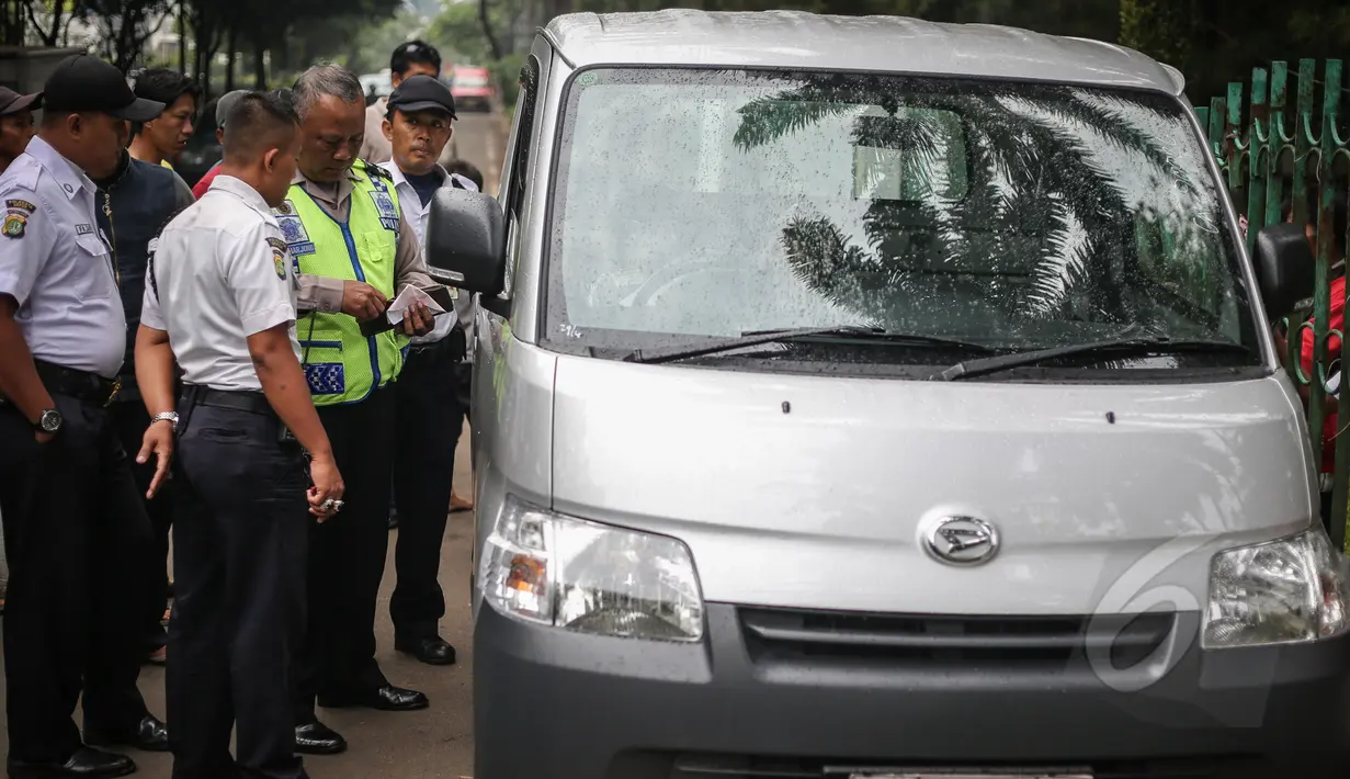 Petugas terlihat mengidentifikasi penemuan mayat pria dalam sebuah mobil di kawasan Taman Wiladatika, Jakarta, Minggu (3/5/2015). Mayat pria yang diduga meninggal karena sakit tersebut ditemukan oleh seorang penyapu jalanan. (Liputan6.com/Faizal Fanani)