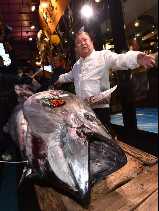 Pengusaha restoran sushi Jepang, Kiyoshi Kimura memamerkan ikan tuna sirip biru seberat 276 kg di restoran utamanya di Tokyo, Minggu (5/1/2020). Tuna raksasa itu dibeli mencapai Rp 24 miliar dan disebut sebagai yang tertinggi kedua dalam rekor lelang ikan di Pasar ikan Toyosu. (Kazuhiro NOGI / AFP)