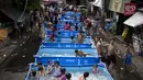 Anak-anak bermain di kolam portabel yang diberikan oleh pemerintah setempat untuk mendinginkan tubuh pada saat musim panas di Manila, Filipina (12/4). (AFP Photo/Noel Celis)