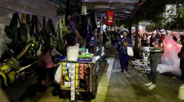 Seorang warga berjalan di trotoar yang dijadikan tempat berjualan pedagang kaki lima (PKL) di Kawasan Bendungan Hilir, Jakarta Pusat, Selasa (30/1). Para PKL ini menggelar dagangannya di bahu jalur pendestrian. (Liputan6.com/JohanTallo)