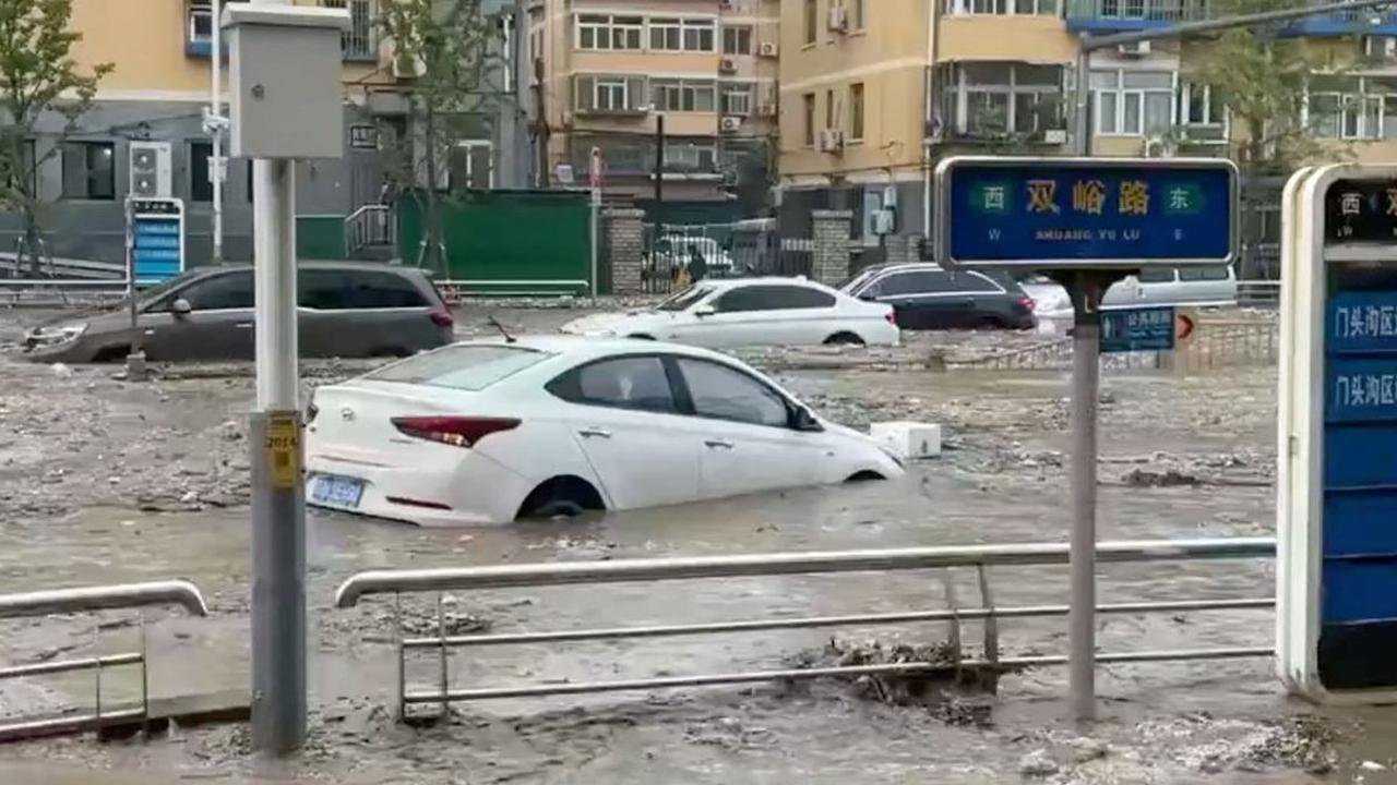 Terjangan banjir memutuskan Jembatan Xiaoqinghe di Distrik Fengtai, Beijing, sehingga membuat beberapa mobil hanyut ke sungai yang arusnya sangat deras.
