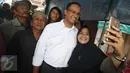 Calon Gubernur DKI Jakarta Anies Baswedan berfoto dengan warga saat mengunjungi Pasar Bambu Kuning, Sunter Agung, Jakarta Utara, Senin (31/10). Di pasar tradisional tersebut, Anies mendengarkan keluhan pedagang (Liputan6.com/Immanuel Antonius)
