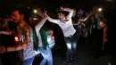 Pendukung Presiden Iran Hassan Rouhani menari di sebuah jalan saat mereka merayakan kemenangannya dalam pemilihan presiden Iran di Teheran, Iran (20/5). (AP Photo/Vahid Salemi)
