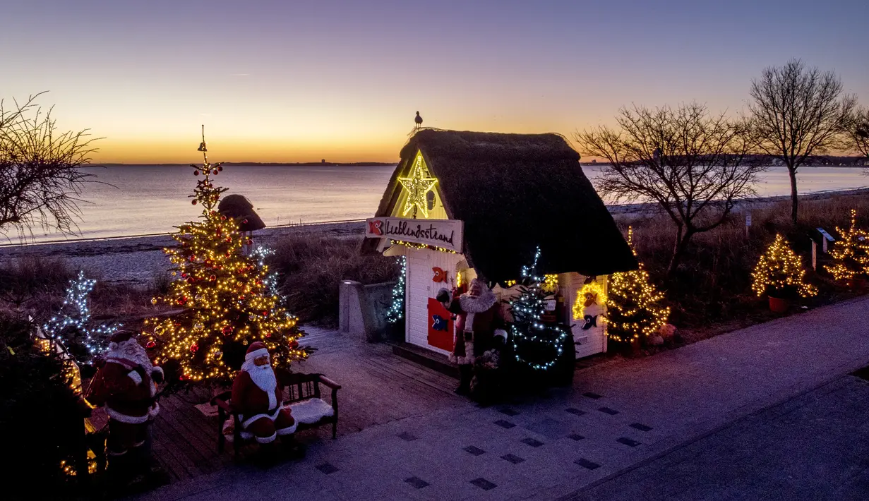 Pohon Natal dan Sinterklas menghiasi pintu masuk pantai di Haffkrug, Jerman utara, Senin (20/12/2021). (AP Photo/Michael Probst)