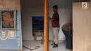 Seniman lukis memasang dinding lapak kios di Sentra Lukisan Pasar Baru, Jakarta, Jumat (16/11). Seniman lukis mengeluh lantaran harus mengeluarkan biaya sendiri untuk memasang dinding kios. (Liputan6.com/Immanuel Antonius)