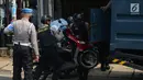 Polisi membawa sepeda motor saat menggelar olah TKP di rumah terduga teroris di Nanggewer, Cibinong, Bogor, Jawa Barat, Sabtu (18/5/2019). Dari lokasi penggerebekan, polisi menyita barang bukti berupa pistol jenis FN dan bahan baku serta bahan jadi peledak. (merdeka.com/Imam Buhori)