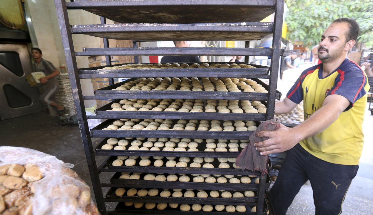 Seorang pekerja membawa permen tradisional "Kahk" untuk perayaan Idul Fitri, Kairo, (27/7/14). (REUTERS/Mohamed Abd El Ghany)