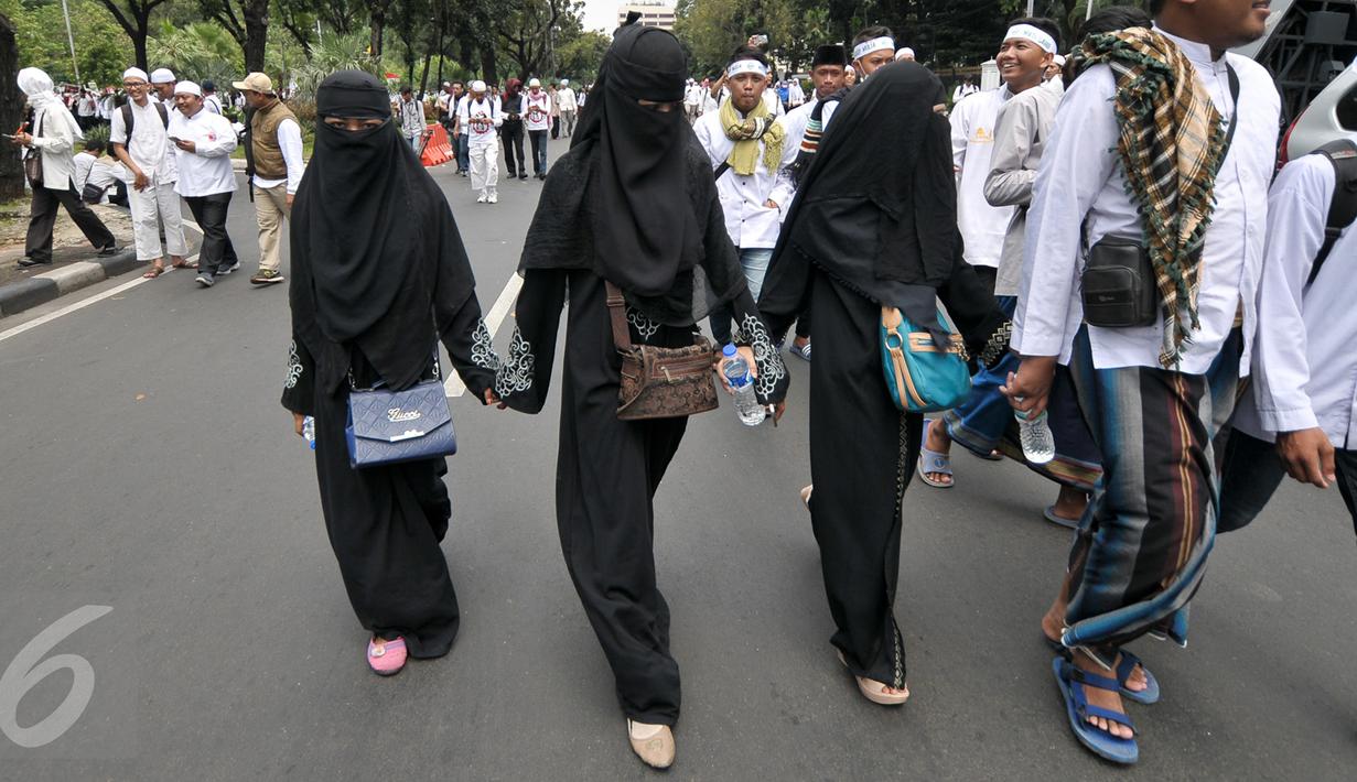 Sejumlah demonstran perempuan mengikuti aksi damai sambil berjalan kaki di Jalan Medan Merdeka Selatan, Jakarta, Jumat (4/11). Ratusan ribu massa aksi damai melakukan aksi menuntut penegakan hukum kasus dugaan penistaan agama. (Liputan6.com/Yoppy Renato)