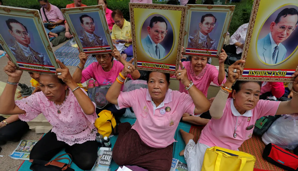 Warga berkumpul di Rumah Sakit Siriraj sambil membawa gambar Raja Thailand Bhumibol Adulyadej di Bangkok, Thailand, Kamis (13/10). Bhumibol meninggal dunia pada usia 88 tahun, setelah sakit dalam beberapa tahun terakhir. (REUTERS / Chaiwat Subprasom)