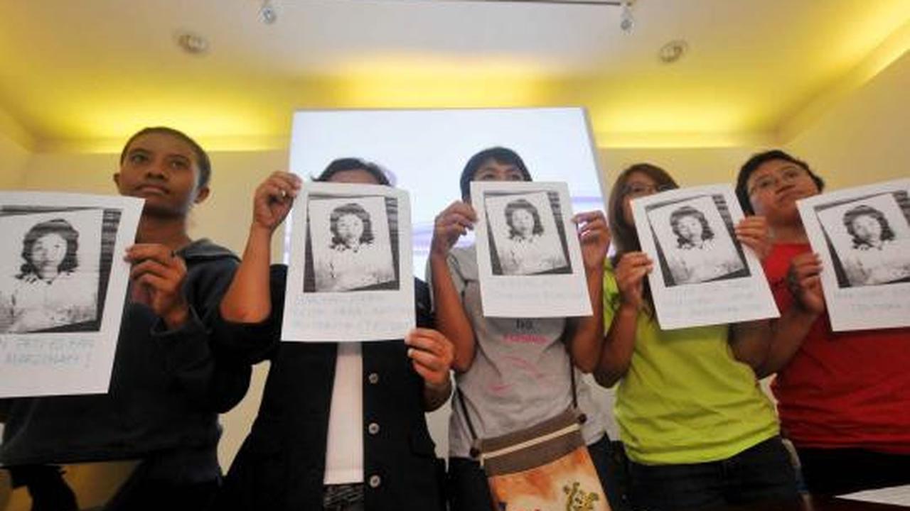 Seorang aktivis menuliskan pesan di foto Marsinah saat konferensi pers 