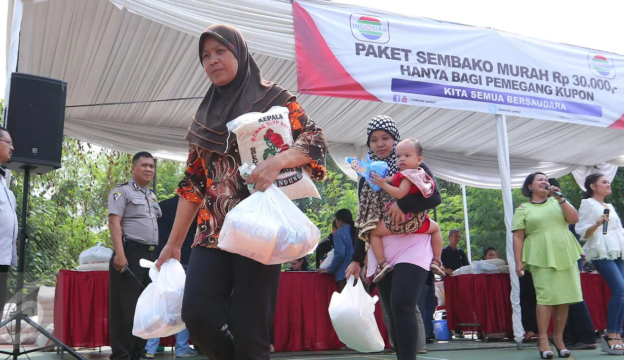 Warga membawa sembako usai mendapatkan paket sembako murah yang diadakan Indosiar di Joglo, Jakarta, Senin (13/6). Paket berisikan 5 kg beras, 2 liter minyak goreng, 1 kg gula pasir dan 1 kg tepung terigu dijual Rp 30 ribu‎. (Liputan6.com/Angga Yuniar)
