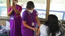 Petugas kesehatan menyuntik seorang pekerja dengan vaksin Covid-19 Covishield di dalam bus penumpang yang diubah menjadi pusat vaksinasi keliling di Kolkata, Kamis (3/6/2021). India telah menderita pandemi yang menghancurkan sejak April, dan baru-baru ini mulai mereda. (Dibyangshu SARKAR/AFP)