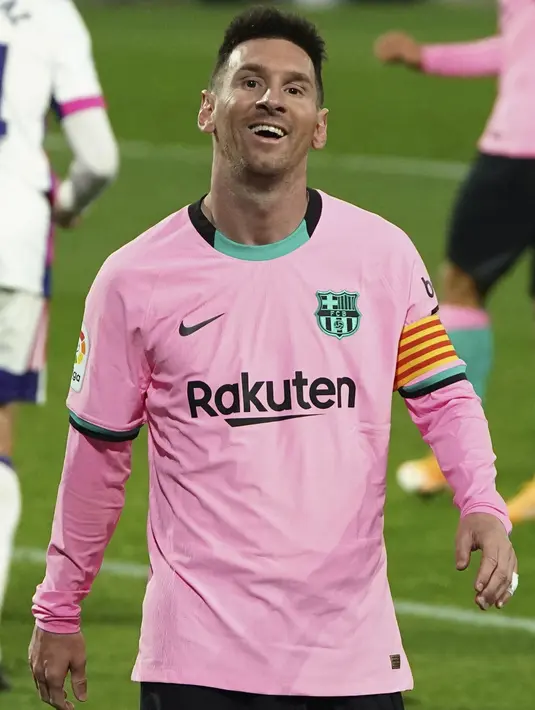 Kapten Barcelona, Lionel Messi tersenyum saat menghadapi Valladolid pada laga pekan ke-15 Liga Spanyol di Stadion Jose Zorrilla, Selasa (22/12/2020). Lionel Messi resmi melewati rekor Pele saat membantu Barcelona menggulung Valladolid 3-0 dalam laga tersebut. (Cesar Manso/Pool via AP)