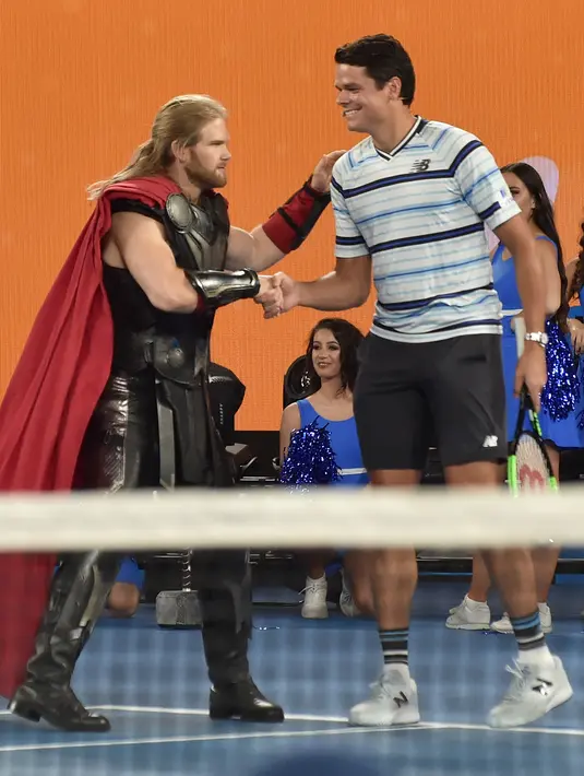 Seorang aktor berpakaian seperti karakter superhero Marvel Thor bersalaman dengan Milos Raonic dari Kanada jelang turnamen tenis Australia Terbuka di Melbourne (13/1). (AFP Photo/Paul Crock)