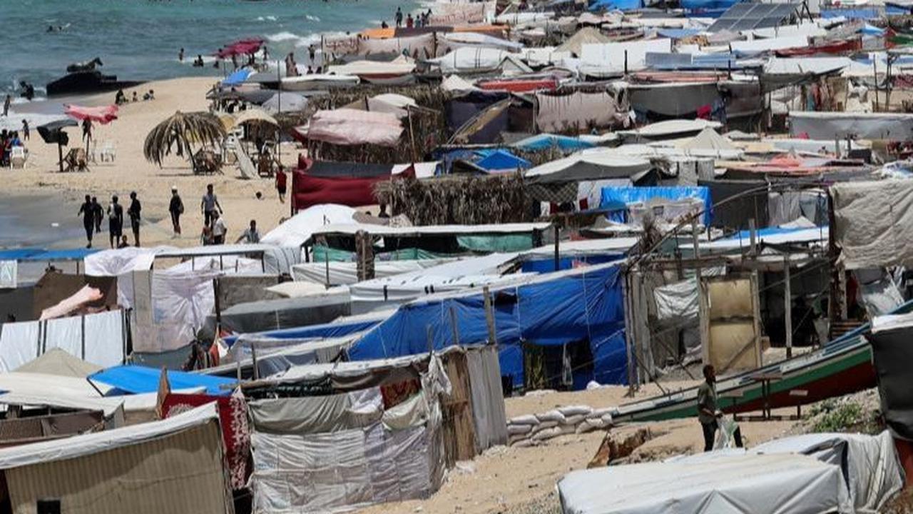 Selain itu, pantai juga menawarkan keuntungan lain, yaitu akses langsung ke air laut yang dapat memberikan sedikit kenyamanan di tengah hari yang panas. Foto: REUTERS / Ramadan Abed<br>