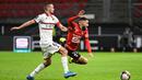 Striker Rennes, Romain Del Castillo (kanan) terjatuh usai perebutan bola dengan gelandang Nice, Morgan Schneiderlin dalam laga lanjutan Liga Prancis 2020/21 pekan ke-27 di Roazhon Park Stadium, Rennes, Jumat, (26/2/2021). Rennes kalah 1-2 dari Nice. (AFP/Damien Meyer)