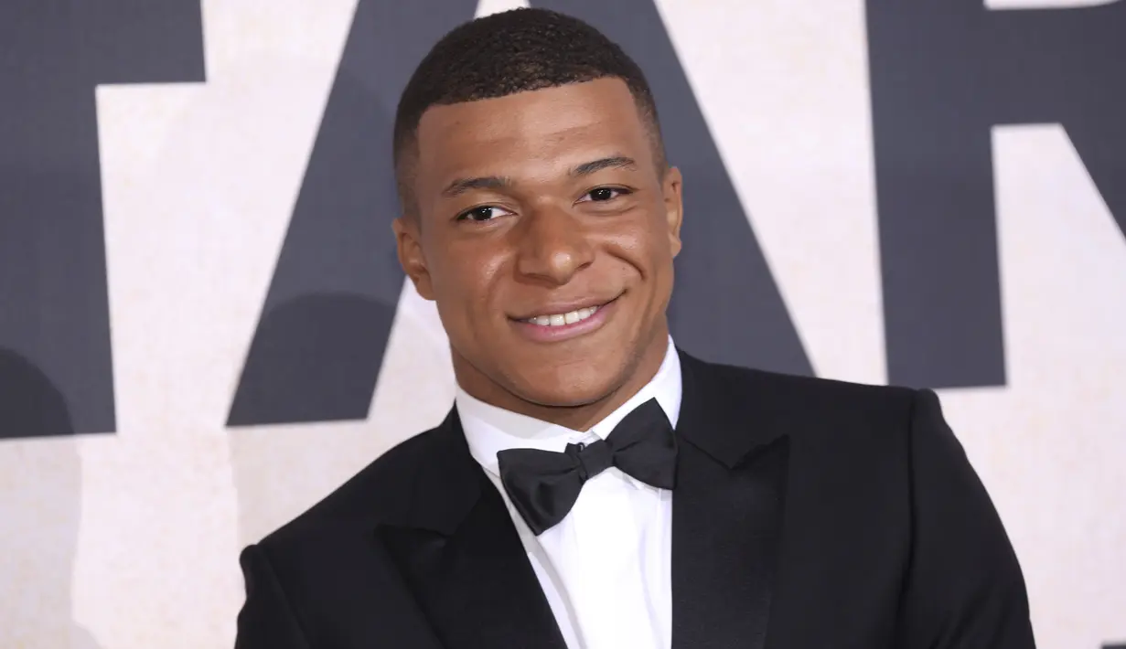 Penyerang PSG, Kylian Mbappe tersenyum setibanya menghadiri AmfAR Cinema Against AIDS Benefit selama festival film internasional Cannes ke-75 di Hotel du Cap-Eden-Roc, Cap d'Antibes, Prancis selatan, Kamis (26/5/2022). Mbappe tampil mengenakan jas hitam berdasi kupu-kupu. (AP Photo/Vianney Le Caer)