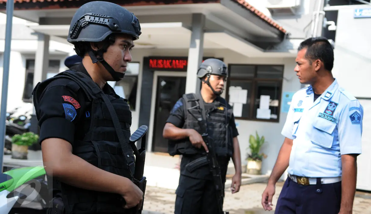 Personel polisi berjaga di sekitar Dermaga Wijayapura menuju LP Nusakambangan, Cilacap, Jateng,dengan menyandang senjata laras panjang, Kamis (28/7). Jelang eksekusi mati, kepolisian melakukan sterilisasi di Pulau Nusakambangan (Liputan6.com/Helmi Afandi)