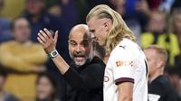 Pelatih Manchester City, Pep Guardiola, tampak memberikan arahan kepada Erling Haaland saat melawan Burnley pada laga pekan perdana Premier League di Stadion Turf Moor, Sabtu (12/8/2023). City menang dengan skor 3-0. (Mike Egerton/PA via AP)