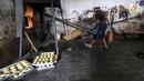 Karyawan mengeluarkan roti usai dipanggang dari dalam tungku di Toko Roti GO, Purwokerto, Jawa Tengah, Senin (22/4). Toko roti yang berdiri sejak tahun 1898 tersebut diproduksi dengan fermentasi (bibit roti) dan tanpa bahan campuran atau pengawet. (Liputan6.com/Fery Pradolo)